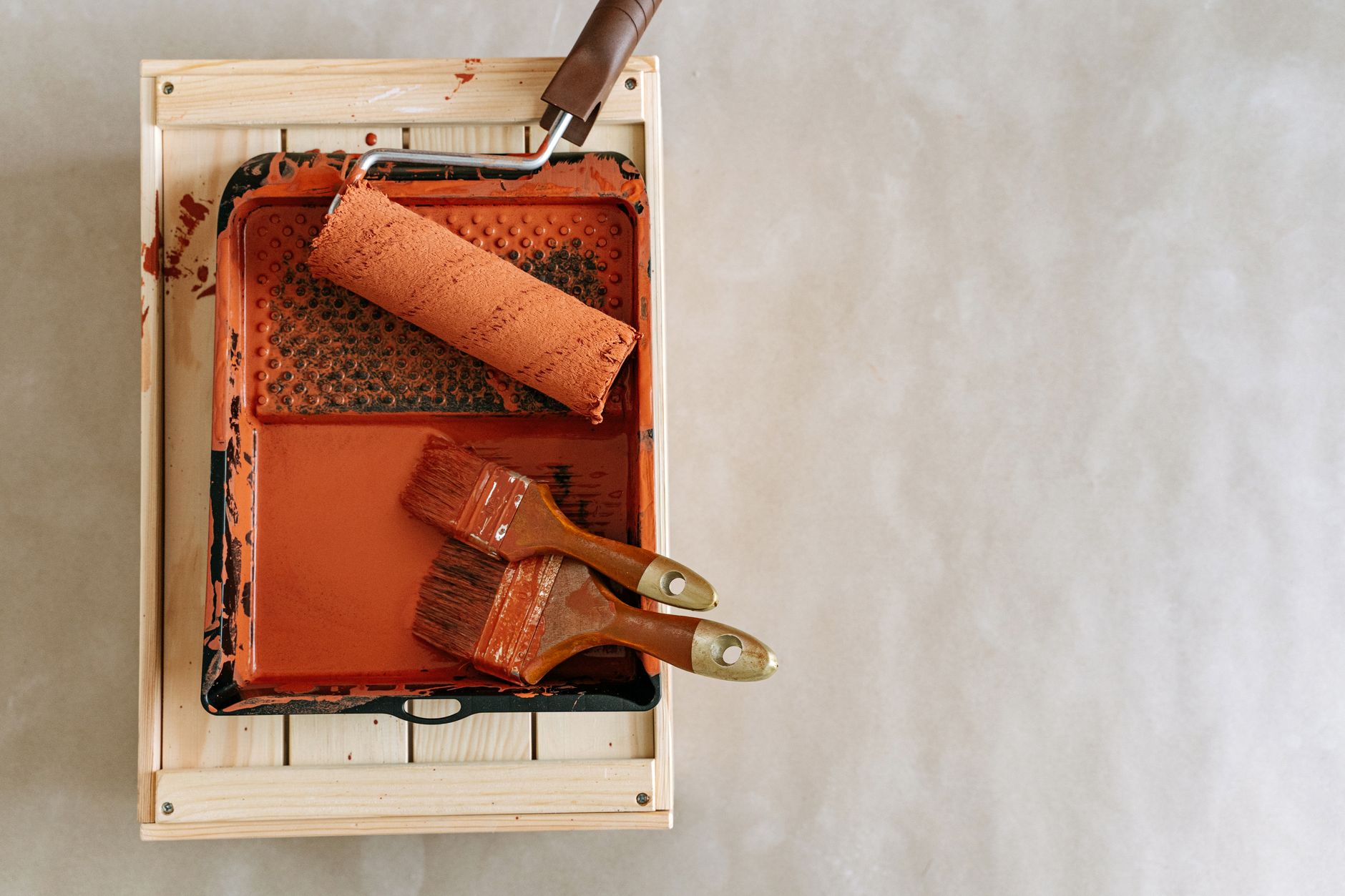 An overhead shot of paintbrushes and a roller in a tray, perfect for home renovation projects. — Get Full-Service Climate Con