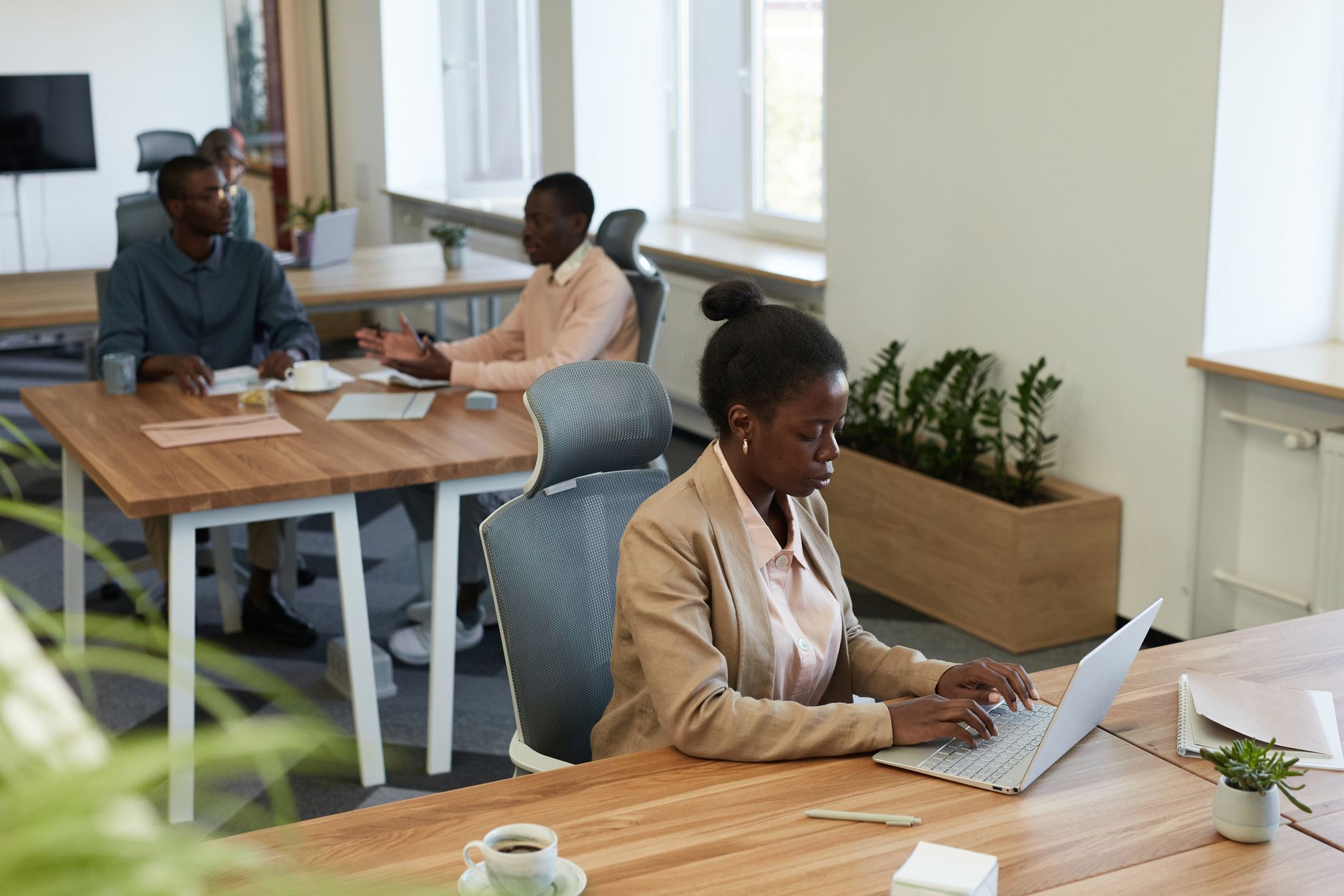 Diverse group of professionals collaborating in a modern office setting with laptops and discussions. — How to Find the Best